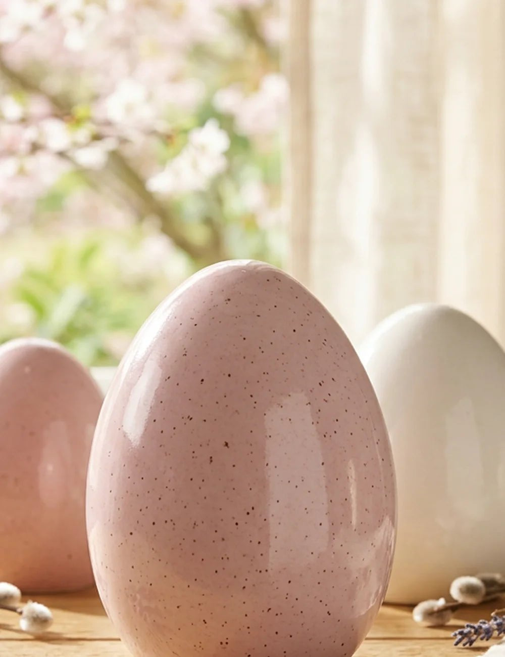 Mylana Porzellan-Ei rosa eingerahmt von Kirschblüten und Lavendel am Fenster