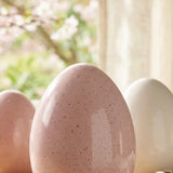 Mylana Porzellan-Ei rosa eingerahmt von Kirschblüten und Lavendel am Fenster