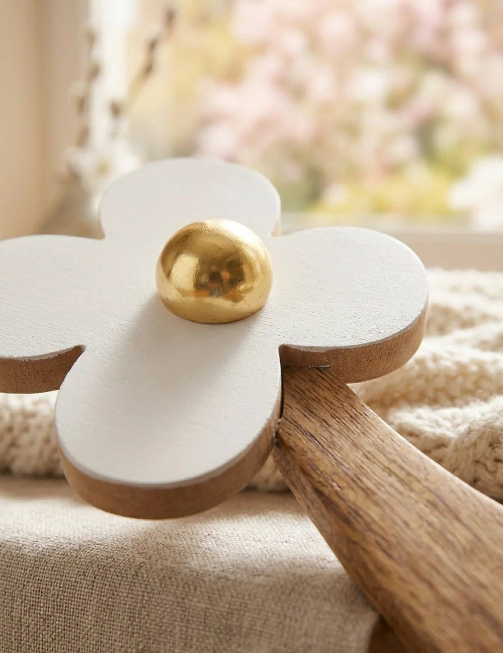 Detailansicht der weißen Holzblüte mit goldener Mitte und Naturholz-Stiel mit Blattmotiv