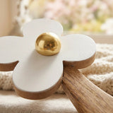 Detailansicht der weißen Holzblüte mit goldener Mitte und Naturholz-Stiel mit Blattmotiv