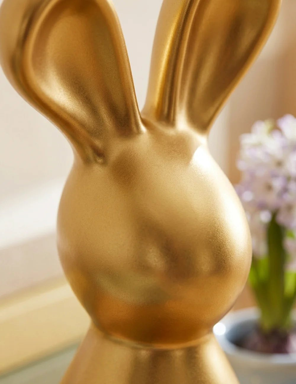 Nahaufnahme goldener Daggy-Hasenkopf mit geschwungenen Ohren und satinierter Metallic-Glasur