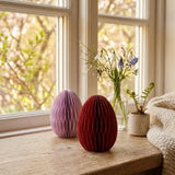 Papiereier Eggo auf sonniger Fensterbank mit Schneeglöckchen und Traubenhyazinthen in Glasvasen