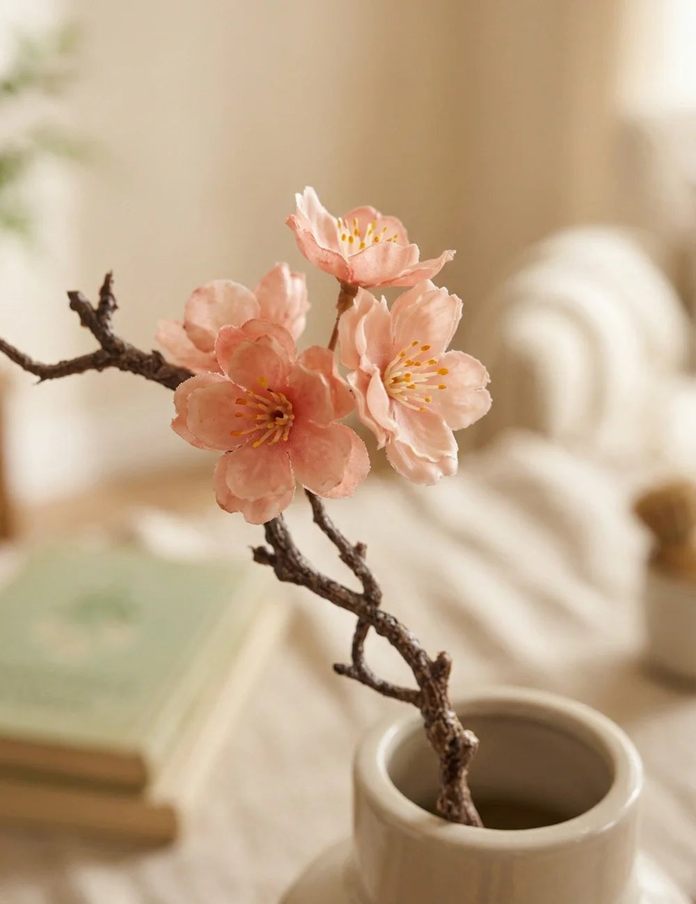 Nahaufnahme rosa Pfirsichblüten mit gelben Staubgefäßen am Kunstzweig