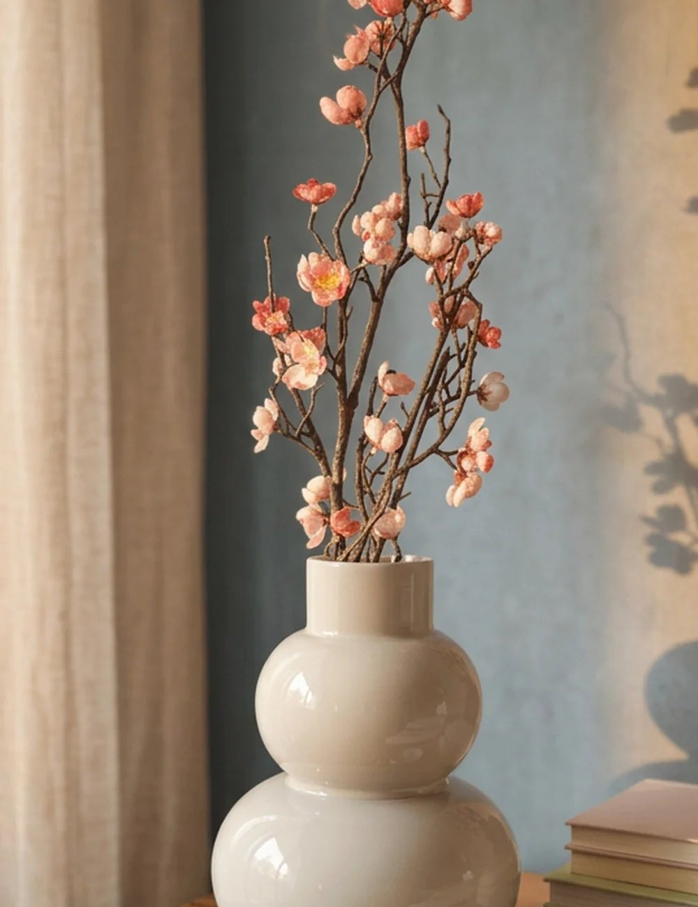 Dekozweig Pfirsichblüte Nahansicht vor Petrolwand mit Leinenvorhang