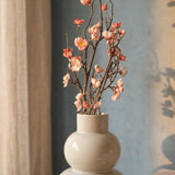 Dekozweig Pfirsichblüte Nahansicht vor Petrolwand mit Leinenvorhang