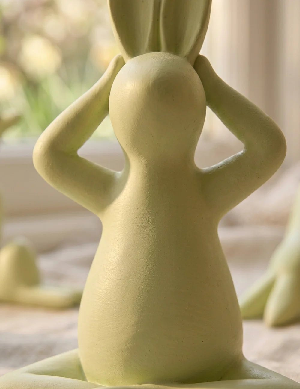 Nahaufnahme meditierender Yoga-Hase von hinten mit matter Oberfläche in Holzoptik