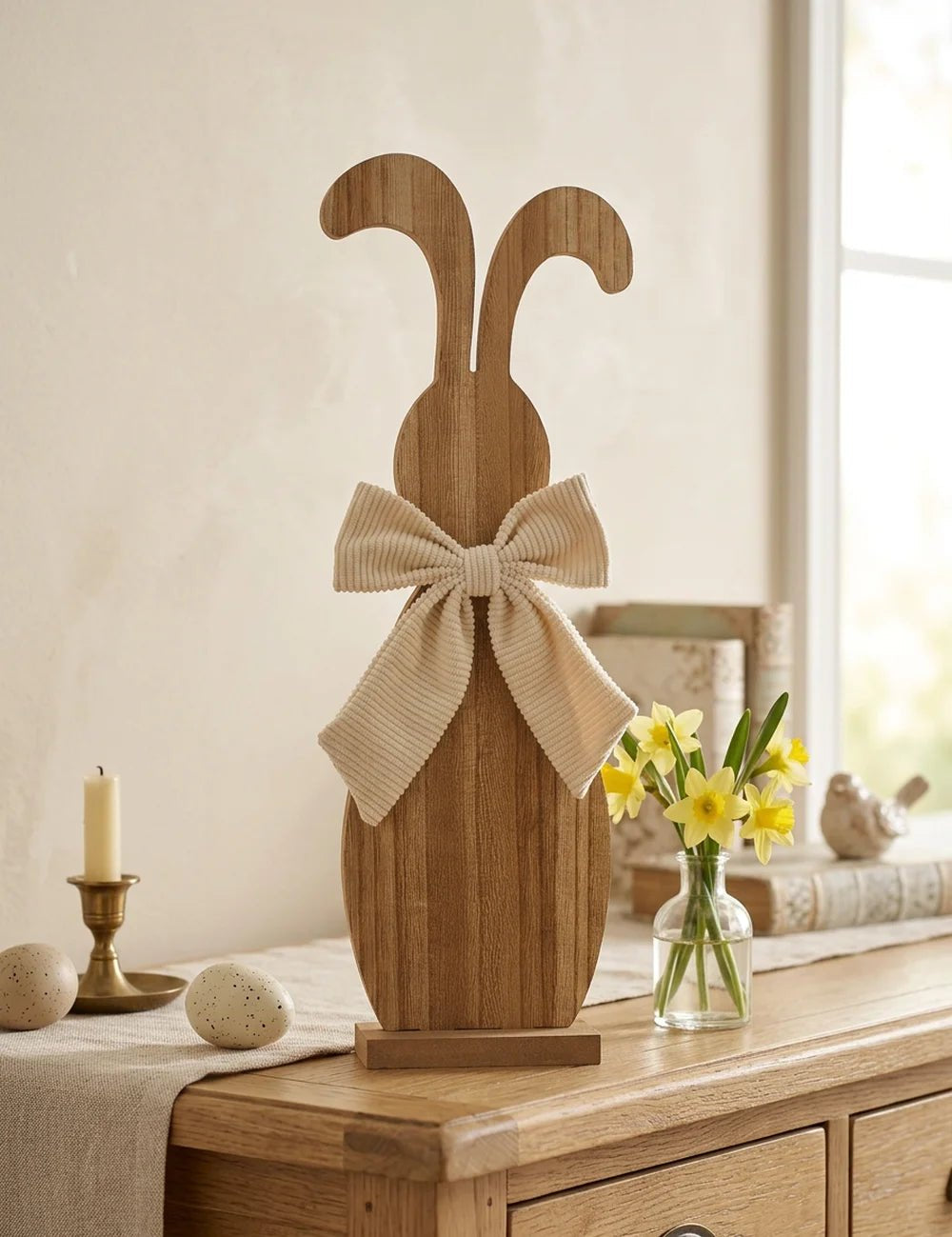 Holzhase Bernado auf Kommode dekoriert mit Kerze, Narzissen und Deko-Eiern