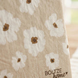 Einzelne Serviette Canea aufgestellt mit Gänseblümchen-Muster in Beige und Boltze-Logo