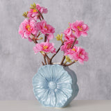 Keramikvase Melany hellblau mit rosa Blütenzweigen vor grauem Hintergrund